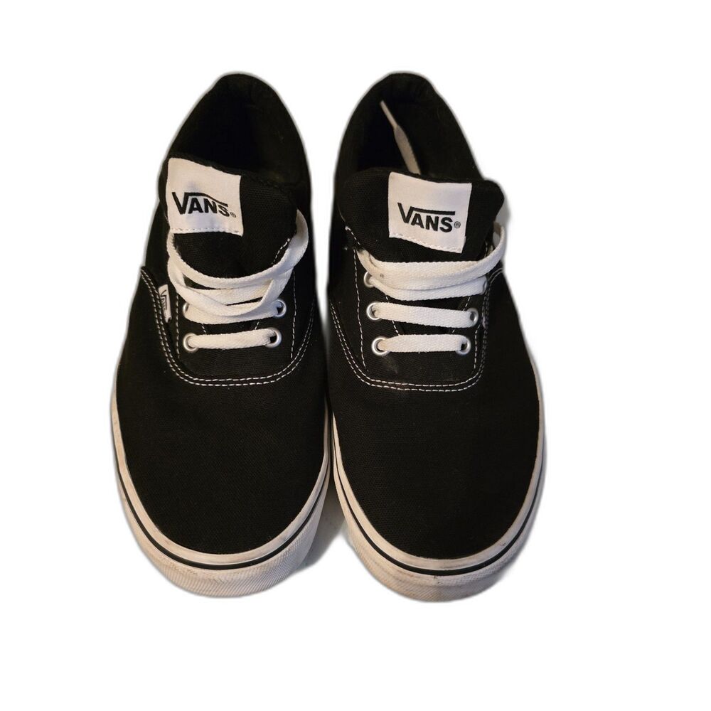 These are black Vans Authentic sneakers with white laces.